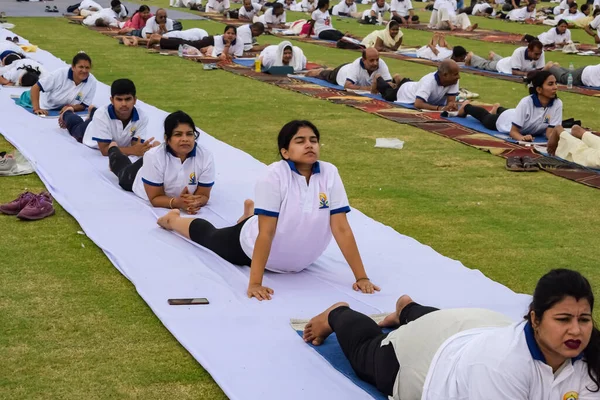 Yeni Delhi, Hindistan, 21 Haziran 2023 - Uluslararası Yoga Günü 'nde Delhi' deki Yamuna Spor Kompleksi 'nde grup Yoga egzersiz oturumu, kriket stadyumunda yoga derslerine katılan büyük bir grup yetişkin