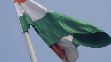 India flag flying high at Connaught Place with pride in blue sky, India flag fluttering, Indian Flag on Independence Day and Republic Day of India, tilt up shot, Waving Indian flag, Har Ghar Tiranga