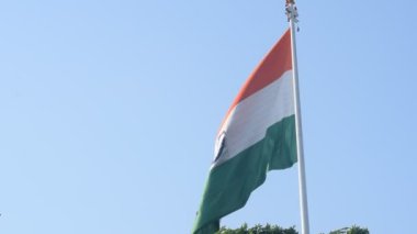 India flag flying high at Connaught Place with pride in blue sky, India flag fluttering, Indian Flag on Independence Day and Republic Day of India, tilt up shot, Waving Indian flag, Har Ghar Tiranga