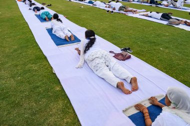 Yeni Delhi, Hindistan, 21 Haziran 2023 - Uluslararası Yoga Günü 'nde Delhi' deki Yamuna Spor Kompleksi 'nde grup Yoga egzersiz oturumu, kriket stadyumunda yoga derslerine katılan büyük bir grup yetişkin