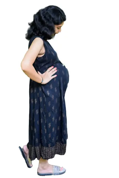 妊娠中のインドの女性は 白い背景を持つ腹に妊娠の撮影と手をポーズ インドの妊娠中の女性は 明白な背景を持つ母性のドレスに彼女の手を置きます 妊娠の撮影 — ストック写真