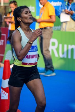 Yeni Delhi, Hindistan - 16 Ekim 2022 - Bitmek üzere olan maraton katılımcılarının bitiş çizgisini geçmek üzere olan Delhi Yarı Maratonu 2022