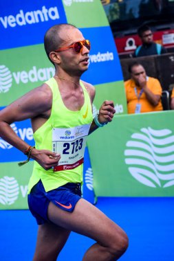 Yeni Delhi, Hindistan - 16 Ekim 2022 - Bitmek üzere olan maraton katılımcılarının bitiş çizgisini geçmek üzere olan Delhi Yarı Maratonu 2022