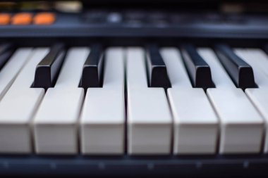 Piyano tuşlarına yakın çekim. Piyano siyah ve beyaz tuşlar ve piyano klavye müzik aleti güneşli bir günde ev balkonuna yerleştirildi.