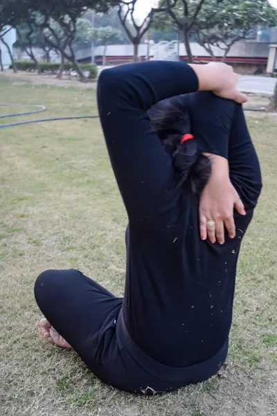 Young Indian woman practicing yoga outdoor in a park. Beautiful girl practice basic yoga pose. Calmness and relax, female happiness. Basic Yoga poses outdoor