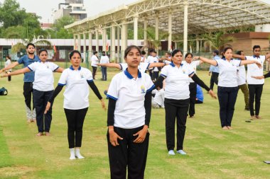 Yeni Delhi, Hindistan, 21 Haziran 2023 - Uluslararası Yoga Günü 'nde Delhi' deki Yamuna Spor Kompleksi 'nde grup Yoga egzersiz oturumu, kriket stadyumunda yoga derslerine katılan büyük bir grup yetişkin