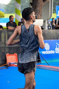 Yeni Delhi, Hindistan - 16 Ekim 2022 - Bitmek üzere olan maraton katılımcılarının bitiş çizgisini geçmek üzere olan Delhi Yarı Maratonu 2022