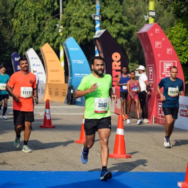 Yeni Delhi, Hindistan - 16 Ekim 2022 - Bitmek üzere olan maraton katılımcılarının bitiş çizgisini geçmek üzere olan Delhi Yarı Maratonu 2022