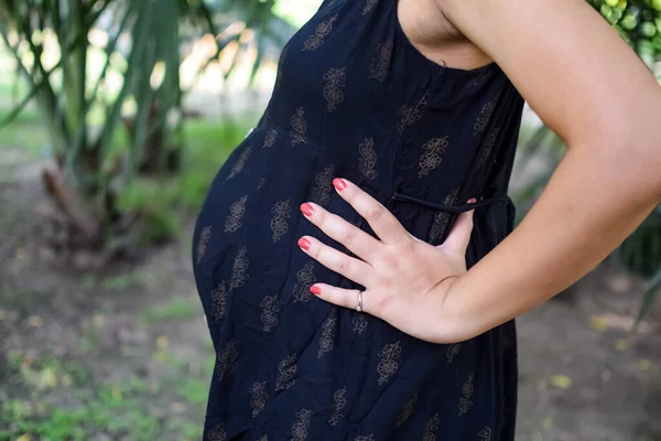 妊娠中のインドの女性は 腹に屋外妊娠の撮影と手をポーズ インドの妊娠中の女性は 社会公園で母性のドレスで彼女の手を置きます 妊娠中の外出産の撮影 — ストック写真