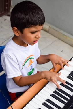 Sentezleyici ya da piyano çalan Asyalı çocuk. Küçük şirin çocuk piyano çalmayı öğreniyor. Çocuk elleri klavyenin içinde.