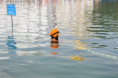 Amritsar, Hindistan - 26 Şubat 2023 - Amritsar, Punjab, Hindistan 'daki Altın Tapınak' ta (Harmandir Sahib) sarovarda kutsal dalış yapan tanımlanamayan dindarlar,