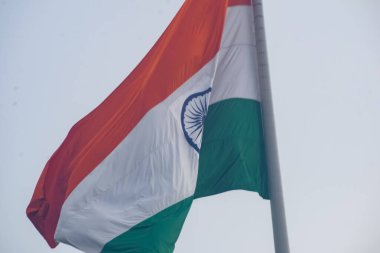 India flag flying high at Connaught Place with pride in blue sky, India flag fluttering, Indian Flag on Independence Day and Republic Day of India, tilt up shot, Waving Indian flag, Har Ghar Tiranga