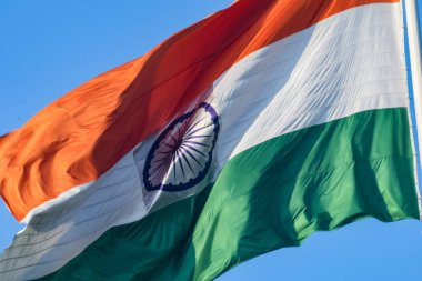 India flag flying high at Connaught Place with pride in blue sky, India flag fluttering, Indian Flag on Independence Day and Republic Day of India, tilt up shot, Waving Indian flag, Har Ghar Tiranga