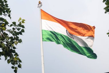 India flag flying high at Connaught Place with pride in blue sky, India flag fluttering, Indian Flag on Independence Day and Republic Day of India, tilt up shot, Waving Indian flag, Har Ghar Tiranga