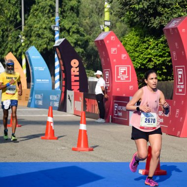 Yeni Delhi, Hindistan - 15 Ekim 2023 - Bitmek üzere olan maraton katılımcılarının bitiş çizgisini geçmek üzere olan Delhi Yarı Maratonu 2022