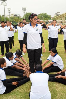 Yeni Delhi, Hindistan, 21 Haziran 2023 - Uluslararası Yoga Günü 'nde Delhi' deki Yamuna Spor Kompleksi 'nde grup Yoga egzersiz oturumu, kriket stadyumunda yoga derslerine katılan büyük bir grup yetişkin