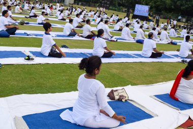 Yeni Delhi, Hindistan, 21 Haziran 2023 - Uluslararası Yoga Günü 'nde Delhi' deki Yamuna Spor Kompleksi 'nde grup Yoga egzersiz oturumu, kriket stadyumunda yoga derslerine katılan büyük bir grup yetişkin