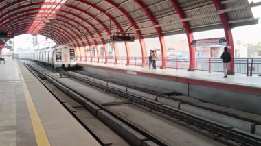 Yeni Delhi Hindistan 09 Ekim 2023 - Delhi Metro treni Yeni Delhi, Hindistan, Asya 'daki Jhandewalan metro istasyonuna yanaşıyor.