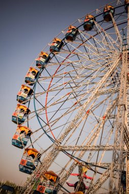 Delhi, Hindistan 'da Dussehra Mela sırasında çok renkli Dev Tekerlek' in yakın çekimi. Dev tekerlek salıncağının alt görüntüsü. Gündüz vakti renkli kamaralı dönme dolap.