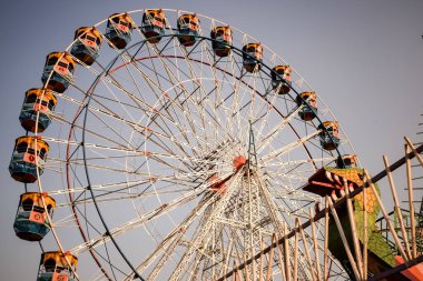 Delhi, Hindistan 'da Dussehra Mela sırasında çok renkli Dev Tekerlek' in yakın çekimi. Dev tekerlek salıncağının alt görüntüsü. Gündüz vakti renkli kamaralı dönme dolap.