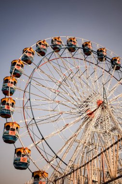 Delhi, Hindistan 'da Dussehra Mela sırasında çok renkli Dev Tekerlek' in yakın çekimi. Dev tekerlek salıncağının alt görüntüsü. Gündüz vakti renkli kamaralı dönme dolap.