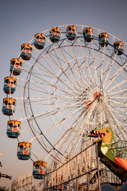 Delhi, Hindistan 'da Dussehra Mela sırasında çok renkli Dev Tekerlek' in yakın çekimi. Dev tekerlek salıncağının alt görüntüsü. Gündüz vakti renkli kamaralı dönme dolap.