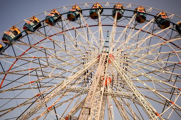 Delhi, Hindistan 'da Dussehra Mela sırasında çok renkli Dev Tekerlek' in yakın çekimi. Dev tekerlek salıncağının alt görüntüsü. Gündüz vakti renkli kamaralı dönme dolap.