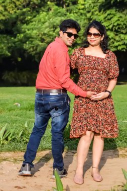 Hintli çift doğum çekimi için poz veriyor. Delhi 'deki Lodhi Road' da yeni doğan bebeğe kucak açıyorlar. Anne ve babalar çocuklarını karşıladıkları için annelik fotoğrafı çekiyorlar.