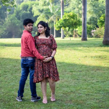 Hintli çift doğum çekimi için poz veriyor. Delhi 'deki Lodhi Road' da yeni doğan bebeğe kucak açıyorlar. Anne ve babalar çocuklarını karşıladıkları için annelik fotoğrafı çekiyorlar.