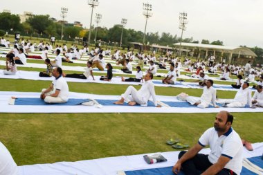 Yeni Delhi, Hindistan, 21 Haziran 2023 - Uluslararası Yoga Günü 'nde Delhi' deki Yamuna Spor Kompleksi 'nde grup Yoga egzersiz oturumu, kriket stadyumunda yoga derslerine katılan büyük bir grup yetişkin