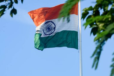 India flag flying high at Connaught Place with pride in blue sky, India flag fluttering, Indian Flag on Independence Day and Republic Day of India, tilt up shot, Waving Indian flag, Har Ghar Tiranga