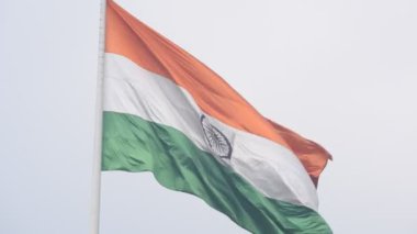 India flag flying high at Connaught Place with pride in blue sky, India flag fluttering, Indian Flag on Independence Day and Republic Day of India, tilt up shot, Waving Indian flag, Har Ghar Tiranga