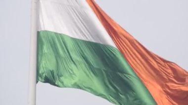 India flag flying high at Connaught Place with pride in blue sky, India flag fluttering, Indian Flag on Independence Day and Republic Day of India, tilt up shot, Waving Indian flag, Har Ghar Tiranga