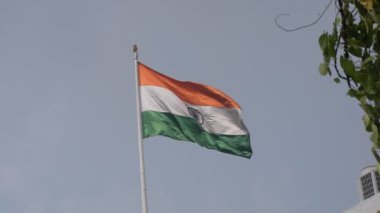 India flag flying high at Connaught Place with pride in blue sky, India flag fluttering, Indian Flag on Independence Day and Republic Day of India, tilt up shot, Waving Indian flag, Har Ghar Tiranga