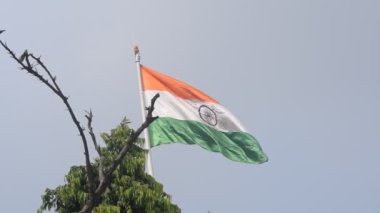 India flag flying high at Connaught Place with pride in blue sky, India flag fluttering, Indian Flag on Independence Day and Republic Day of India, tilt up shot, Waving Indian flag, Har Ghar Tiranga