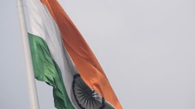 India flag flying high at Connaught Place with pride in blue sky, India flag fluttering, Indian Flag on Independence Day and Republic Day of India, tilt up shot, Waving Indian flag, Har Ghar Tiranga