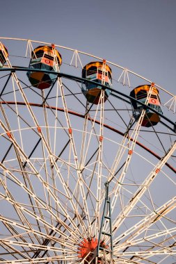 Delhi, Hindistan 'da Dussehra Mela sırasında çok renkli Dev Tekerlek' in yakın çekimi. Dev tekerlek salıncağının alt görüntüsü. Gündüz vakti renkli kamaralı dönme dolap.