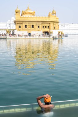 Amritsar, Hindistan - 26 Şubat 2023 - Amritsar, Punjab, Hindistan 'daki Altın Tapınak' ta (Harmandir Sahib) sarovarda kutsal dalış yapan tanımlanamayan dindarlar,