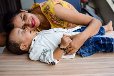 Sevgi dolu anne bebeğini balkonda taşıyor. Mutlu bir annenin parlak portresi. Çocuğu elinde tutuyor. Anne ve 1 yaşındaki küçük oğlu..