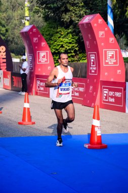 Yeni Delhi, Hindistan - 15 Ekim 2023 - Bitmek üzere olan maraton katılımcılarının bitiş çizgisini geçmek üzere olan Delhi Yarı Maratonu 2023