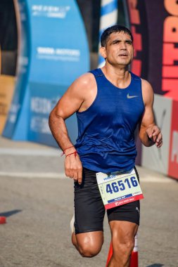 Yeni Delhi, Hindistan - 15 Ekim 2023 - Bitmek üzere olan maraton katılımcılarının bitiş çizgisini geçmek üzere olan Delhi Yarı Maratonu 2023