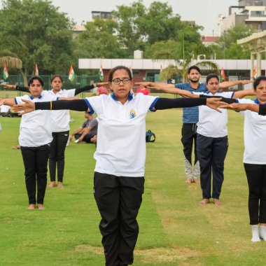 Yeni Delhi, Hindistan, 21 Haziran 2023 - Uluslararası Yoga Günü 'nde Delhi' deki Yamuna Spor Kompleksi 'nde grup Yoga egzersiz oturumu, kriket stadyumunda yoga derslerine katılan büyük bir grup yetişkin