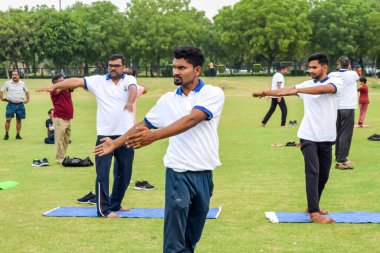 Yeni Delhi, Hindistan, 21 Haziran 2023 - Uluslararası Yoga Günü 'nde Delhi' deki Yamuna Spor Kompleksi 'nde grup Yoga egzersiz oturumu, kriket stadyumunda yoga derslerine katılan büyük bir grup yetişkin