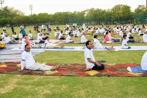 Yeni Delhi, Hindistan, 21 Haziran 2023 - Uluslararası Yoga Günü 'nde Delhi' deki Yamuna Spor Kompleksi 'nde grup Yoga egzersiz oturumu, kriket stadyumunda yoga derslerine katılan büyük bir grup yetişkin