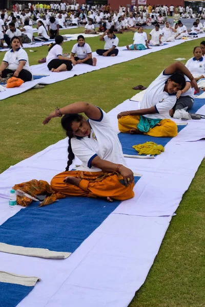 Yeni Delhi, Hindistan, 21 Haziran 2023 - Uluslararası Yoga Günü 'nde Delhi' deki Yamuna Spor Kompleksi 'nde grup Yoga egzersiz oturumu, kriket stadyumunda yoga derslerine katılan büyük bir grup yetişkin