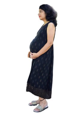 Hamile bir Hintli kadın hamilelik çekimi için poz veriyor ve elleri beyaz arka planda, Hintli hamile kadın elini karnının üstüne koyuyor.