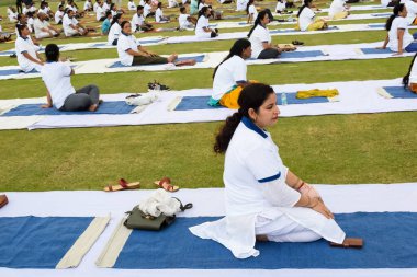 Yeni Delhi, Hindistan, 21 Haziran 2023 - Uluslararası Yoga Günü 'nde Delhi' deki Yamuna Spor Kompleksi 'nde grup Yoga egzersiz oturumu, kriket stadyumunda yoga derslerine katılan büyük bir grup yetişkin