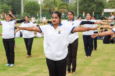 Yeni Delhi, Hindistan, 21 Haziran 2023 - Uluslararası Yoga Günü 'nde Delhi' deki Yamuna Spor Kompleksi 'nde grup Yoga egzersiz oturumu, kriket stadyumunda yoga derslerine katılan büyük bir grup yetişkin