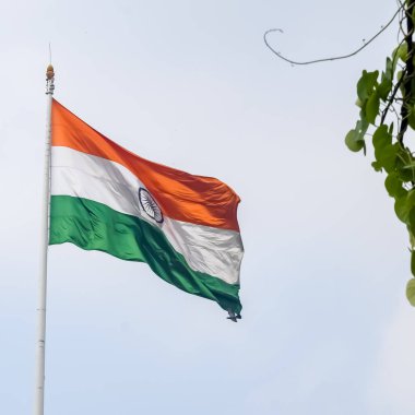 India flag flying high at Connaught Place with pride in blue sky, India flag fluttering, Indian Flag on Independence Day and Republic Day of India, tilt up shot, Waving Indian flag, Har Ghar Tiranga