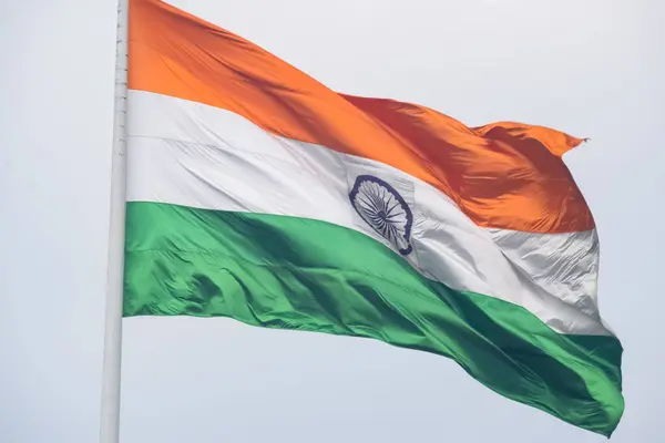 stock image India flag flying high at Connaught Place with pride in blue sky, India flag fluttering, Indian Flag on Independence Day and Republic Day of India, tilt up shot, Waving Indian flag, Har Ghar Tiranga